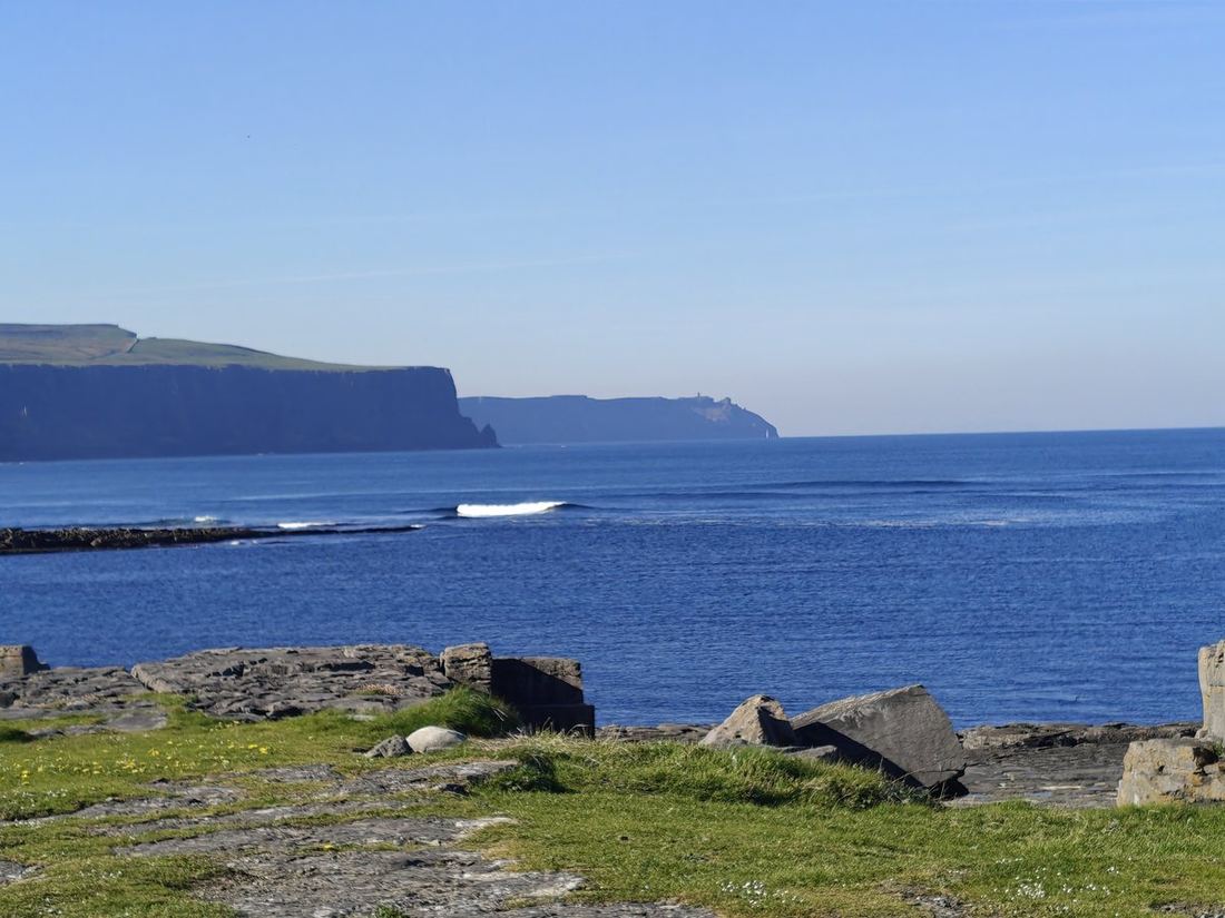The Cliffs of Moher from a grassy headland on a clear day